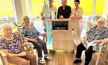 Entspannung auf Rädern: Kursana-Direktor Jonas Günther (hinten Mitte) freut sich mit seinem Team und der Bewohnerschaft über den neuen Snoezelwagen.