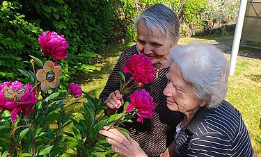 Die Bewohnerinnen freuen sich über die Blumenpracht im Garten.