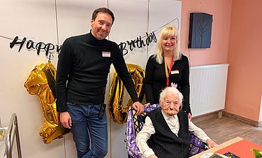 Direktor Dennis Schatton und Jennifer Giestel (Leiterin der soz. Betreuung) gratulieren Elisabeth Auer zu ihrem 100. Geburtstag.