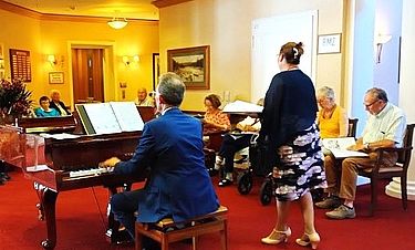 Gemeinsam mit Eva Krumme und Pianist Andeas Arenz singen die Senioren in der Kursana Villa beim Mitmachkonzert beliebte Volkslieder.