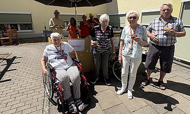 Der improvisierte Stand für Bratwürste und Frikadellen im Hof des Kursana Domizils entwickelte sich zum Treffpunkt und zur Plauderrunde.