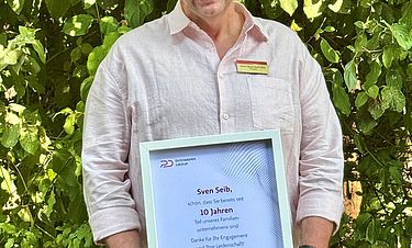 Stolz auf das gemeinsam Erreichte: Sven Maximilian Seib mit der Urkunde zum Zehnjährigen.