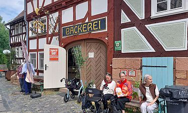 Für die Senioren aus der Kursana Villa Oberursel sah im Hessenpark vieles so aus wie früher: Schmucke Fachwerkhäuser, Handwerksbetriebe und eine Bäckerei, an der sie beim Rundgang eine Pause einlegten.