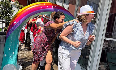 Mitarbeitende des Domizils erfrischen sich unter dem Regenbogen. 
